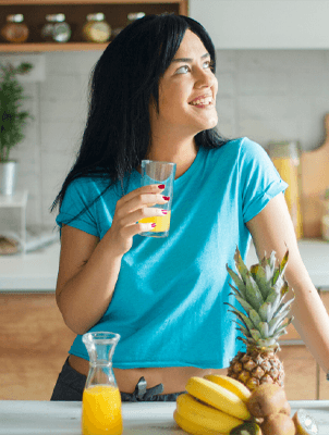 Woman holding orange slice, representing tooth enamel protection